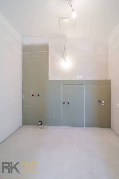 Üres szoba egy építés alatt álló háromszobás lakásban, bekötésekkel az installációkhoz.