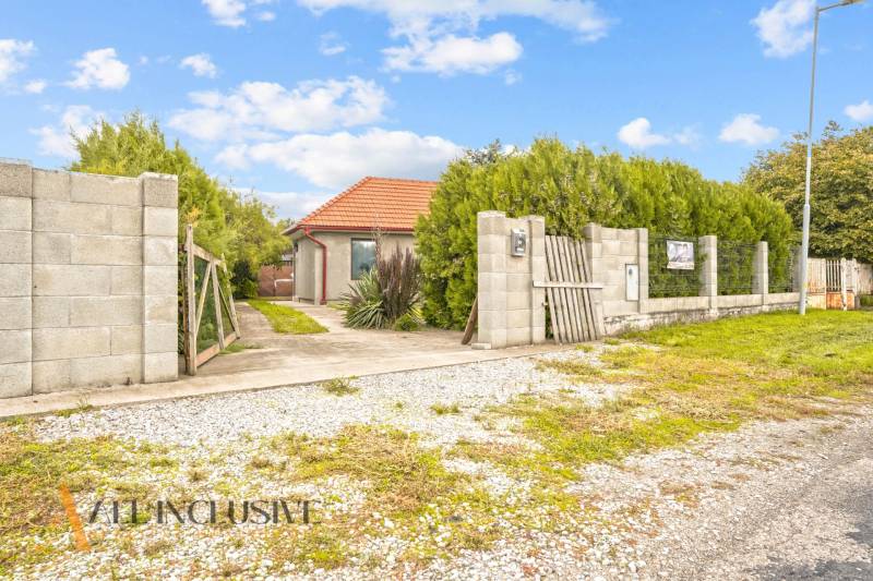 Családi ház Bátorkeszin, zölddel körülvéve, ösvénnyel a kapuhoz vezetve.