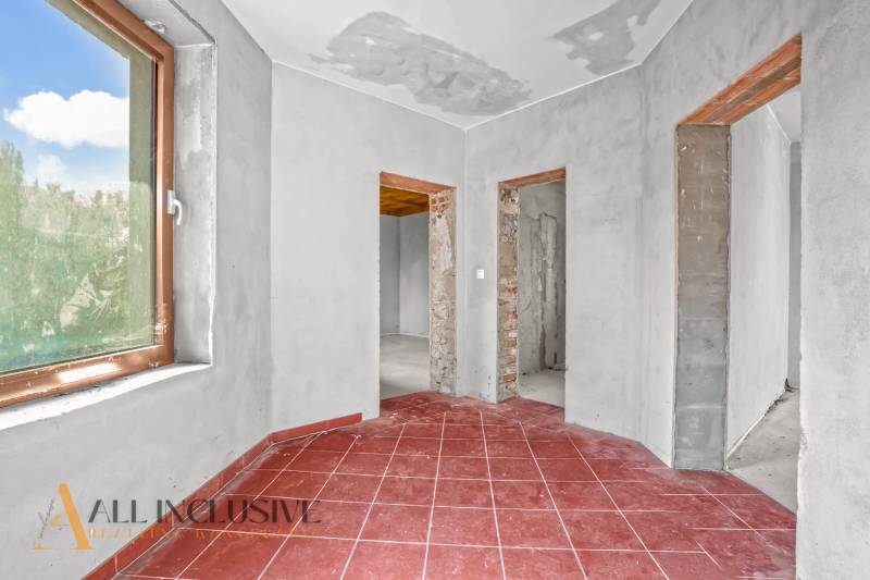 Családi ház piros csempével, vakolt falakkal és három nyitott átjáróval.