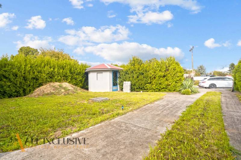 Családi ház udvara Bátorkeszin gyepesítéssel és kerti házikóval.