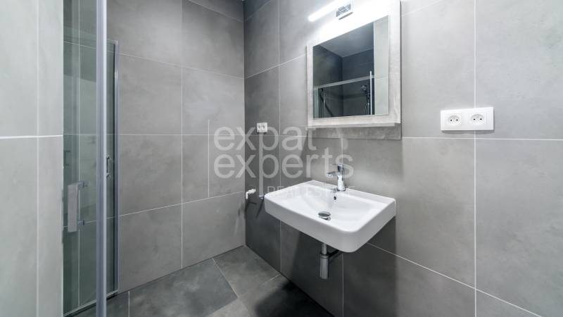 Fürdőszobai felszerelés egy háromszobás lakásban mosdóval és zuhanyzóval.