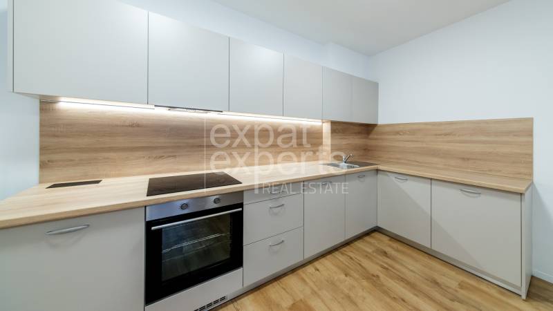 Konyha egy háromszobás lakásban, fa dekoros padlóval és beépített készülékekkel.