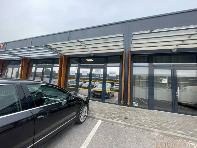 Kereskedelmi helyiségek a Brnianska utcában, Trencsénben, üveg homlokzattal és parkolóval.