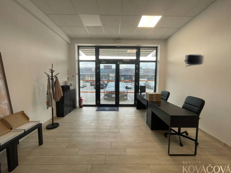 Kereskedelmi helyiségek belső tere bútorokkal és fa dekorációjú padlóval.