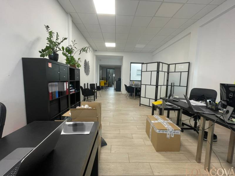 Üzlethelyiség polcokkal, asztalokkal, székekkel és fa dekorációjú padlóval.