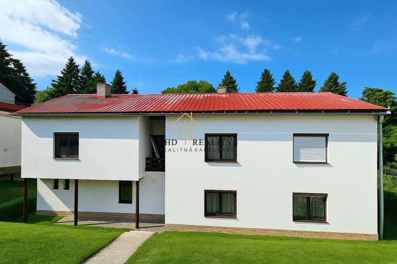 Családi ház Hájikon, Besztercebányán, piros árnyalatú tetővel és ablakokkal.