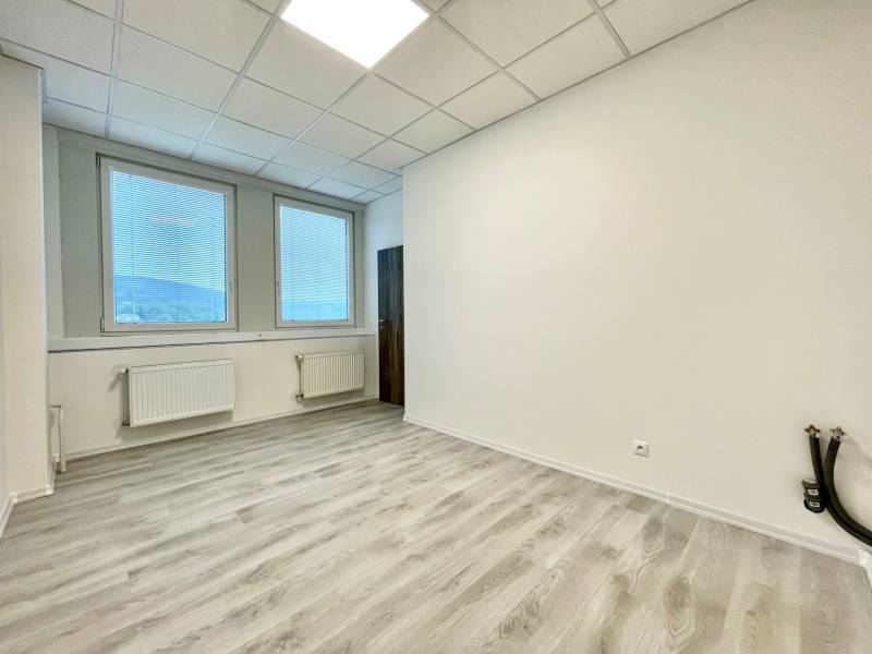 Irodák fa dekor padlóval és nagy ablakokkal, redőnyökkel.