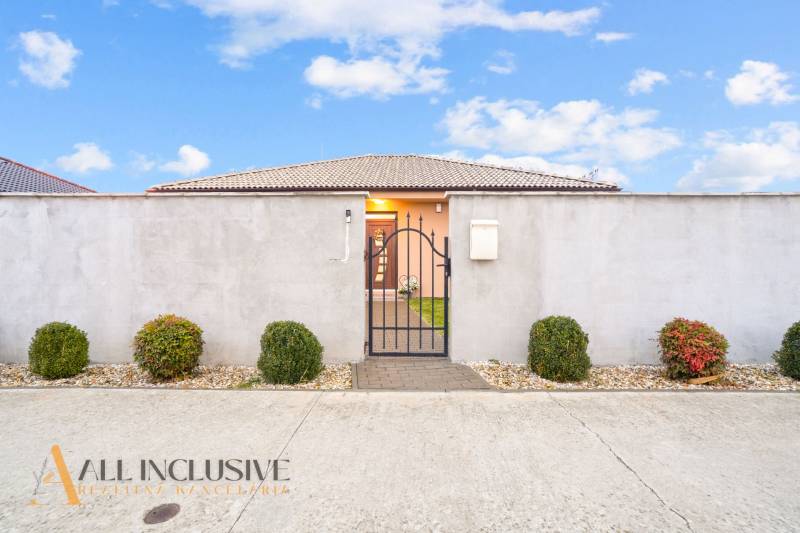 Családi ház Gabčíkovo-ban kerítéssel, kapuval és díszcserjékkel.