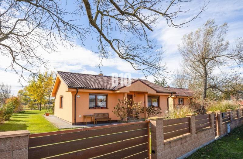 Családi ház Bikó Humencon előkerttel és fákkal a rendezett telken.