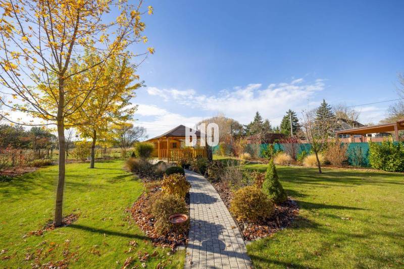 Kert a Bílkova Humencében pavilonnal és színes levelekkel díszített fákkal a családi házban.