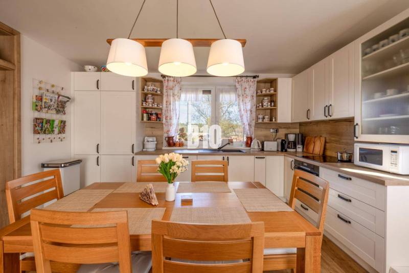 Konyha családi házban fa dekorációval és étkezőasztallal.