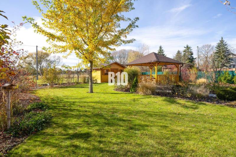 A családi ház kertje Bílkova Humencében, pavilonnal és zöld gyepfelülettel.