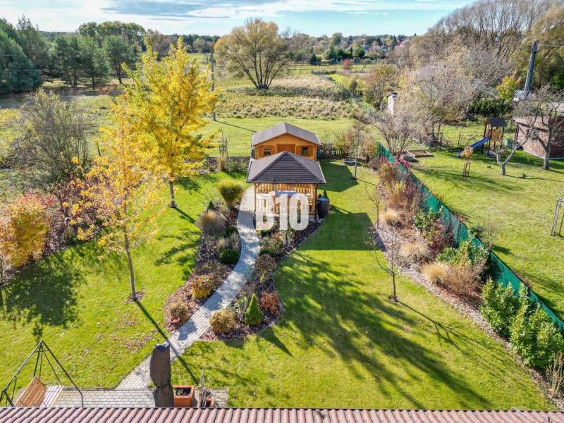 Családi ház kertje Bílkove Humence-ben kerti pavilonnal és zöld növényzettel.