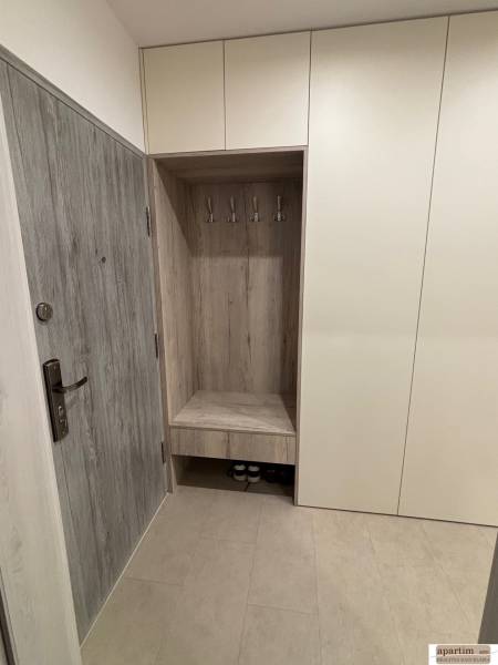 Előszoba szekrényekkel és fogasokkal egy kétszobás lakásban, fa dekoráció az ajtókon.