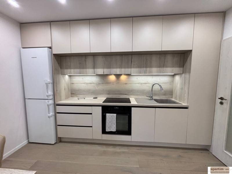 Konyhapult fa dekorral és beépített készülékekkel egy 2 szobás lakásban.