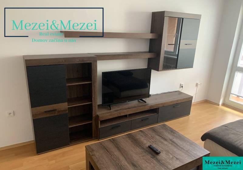 Nappali bútorokkal és televízióval, fa dekorációjú padlóval egy kétszobás lakásban.