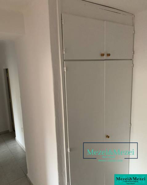 Fehér beépített tároló és csempe egy kétszobás lakásban.