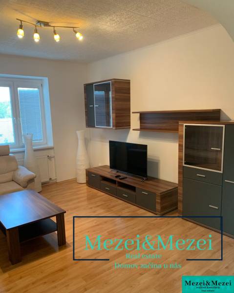 Nappali fapadló dekorral, televízióval és kényelmes kanapéval egy kétszobás lakásban.