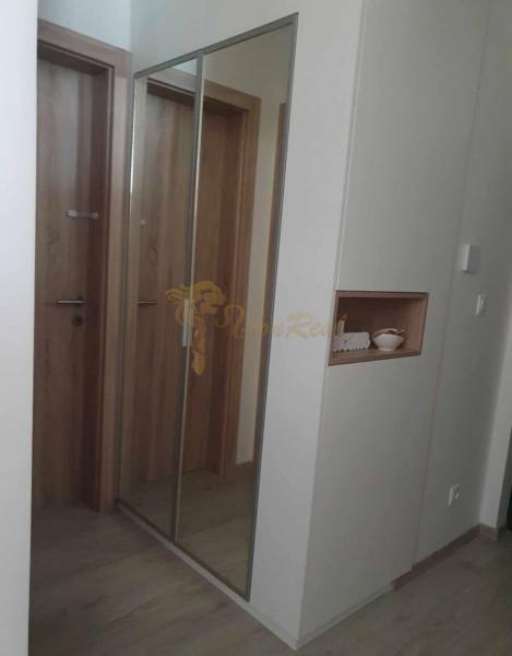 Folyosó nagy tükörrel és fa dekorációjú padlóval egy kétszobás lakásban.