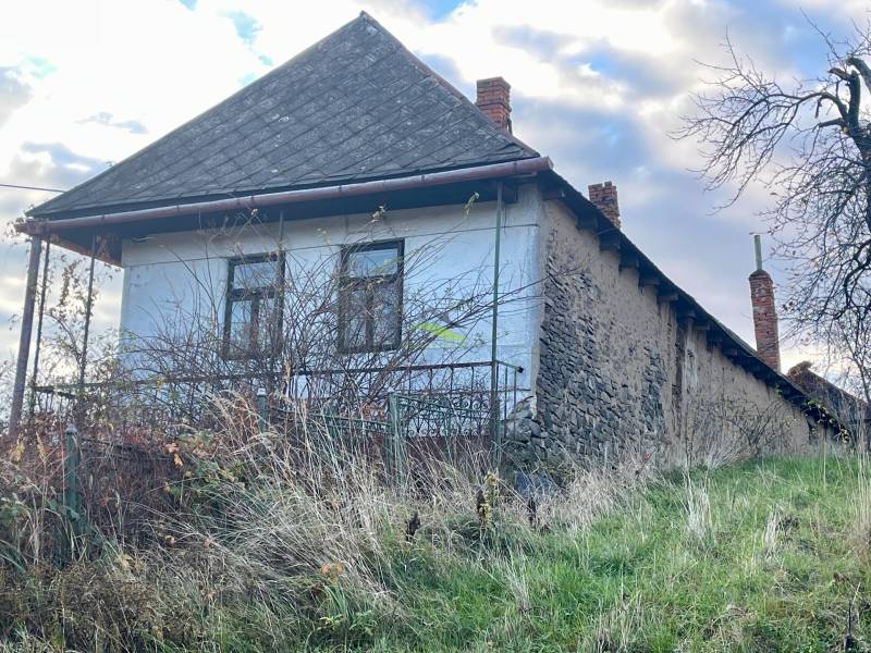 Családi ház a Fő utcán Felsőremetén kőfalakkal és régi tetővel.