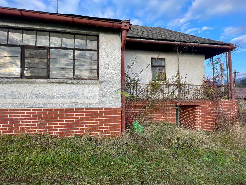 Családi ház a Fő utcán, Felsőremetén, téglából készült lábazattal és elhanyagolt kerttel.