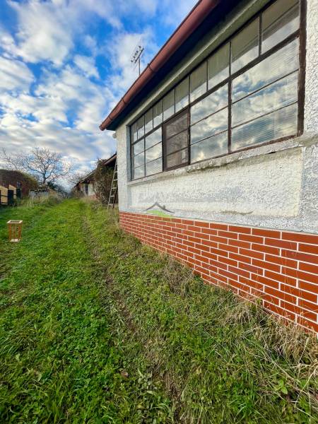 Családi ház a Fő utcán Felsőremetén, téglafalú homlokzattal és nagy ablakokkal.