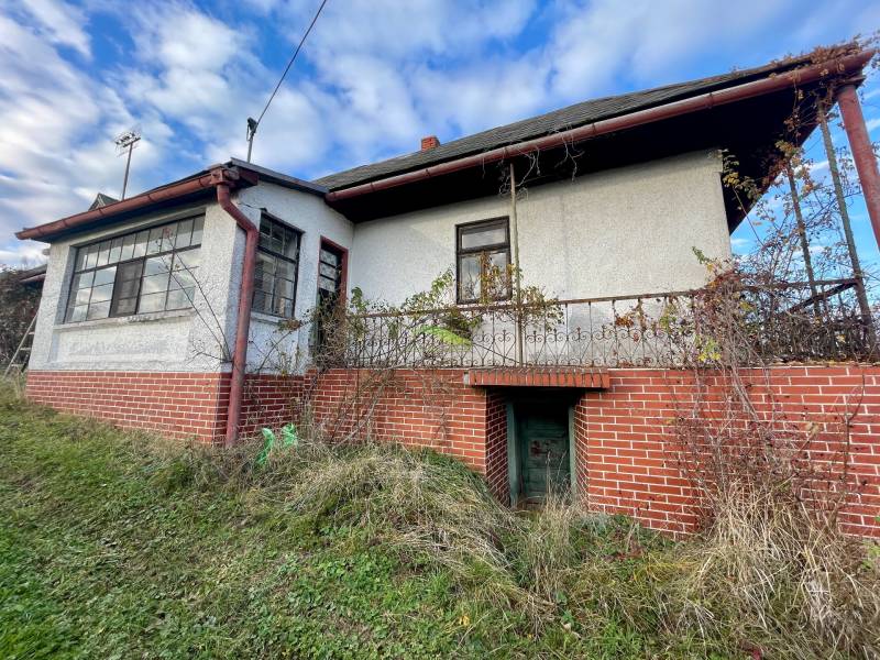 Családi ház a Fő utcán Felsőremetén régebbi homlokzattal és téglaburkolatú lábazattal.