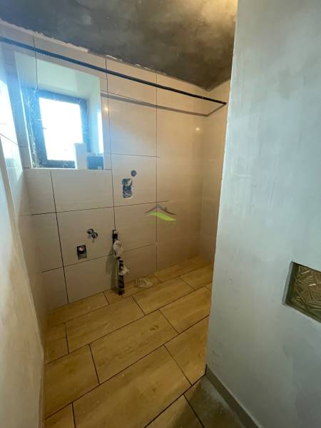 Fürdőszoba családi házban fa mintázatú padlóval és burkolattal.