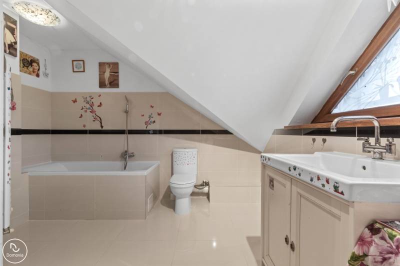 Fürdőszoba családi házban káddal, WC-vel és dekoratív matricákkal a falakon.