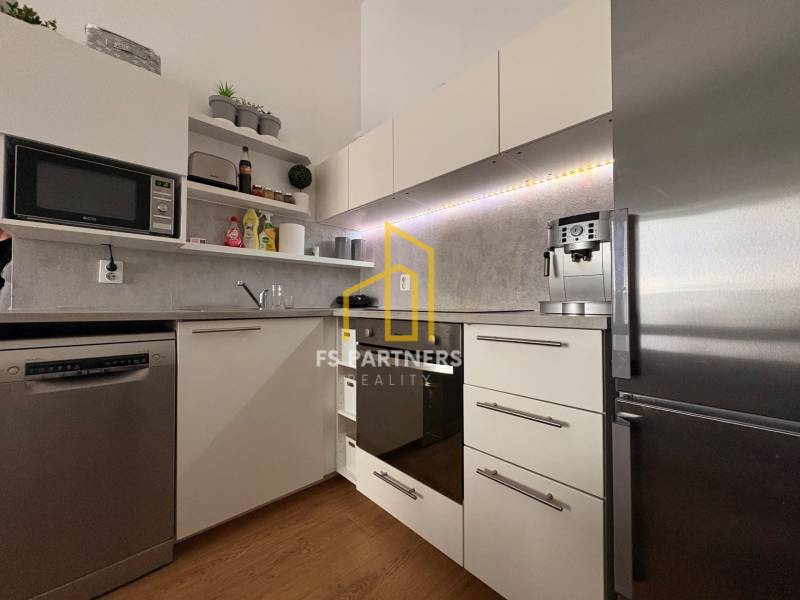 Konyha egy kétszobás lakásban, fa dekor padlóval és modern készülékekkel.