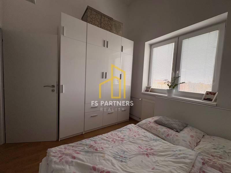 Hálószoba egy kétszobás lakásban fa dekor padlóval és nagy szekrénnyel.