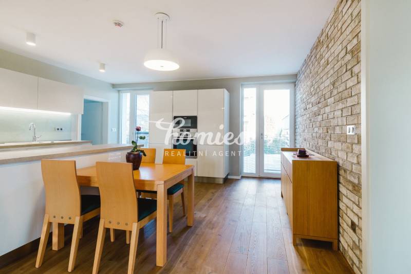 Konyha családi házban téglafallal és fa mintázatú padlóval.