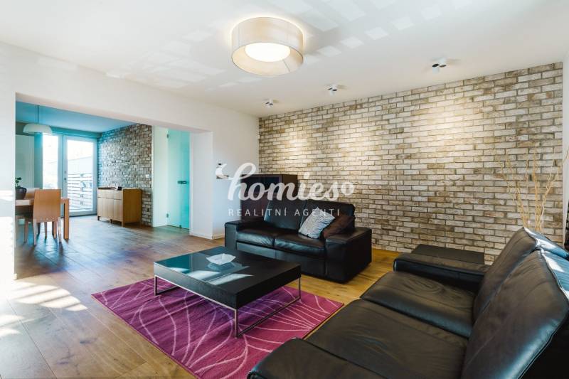 Nappali egy családi házban téglafallal és fa mintázatú padlóval.