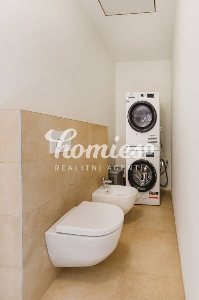 Fürdőszoba családi házban mosógéppel, szárítógéppel, bidével és WC-vel.