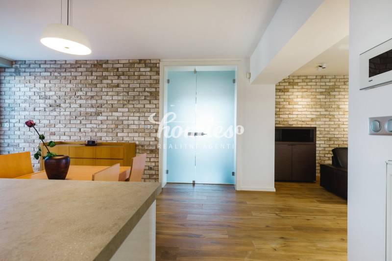 Családi ház étkezője téglafallal és fa dekorációjú padlóval.