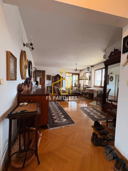 Öt vagy több szobás lakás fa dekor padlóval, klasszikus bútorokkal és szőnyegekkel.