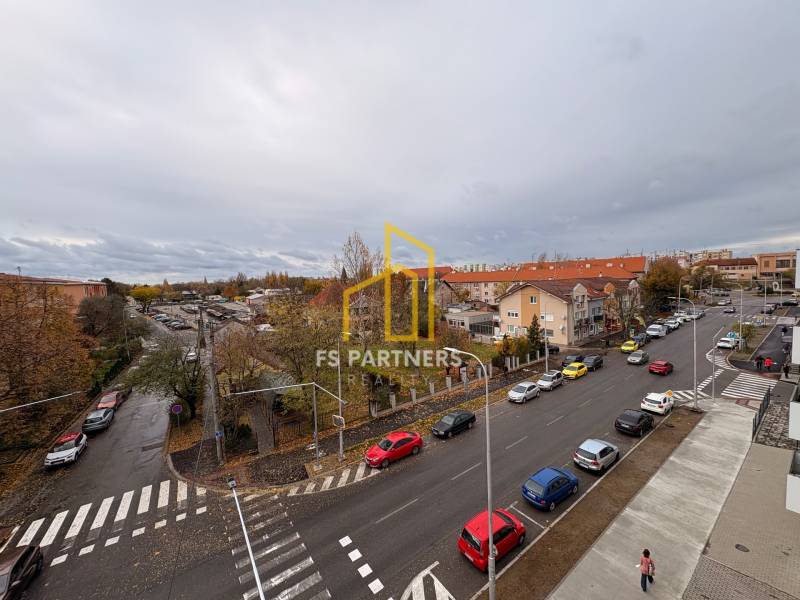 Kilátás az utcára autókkal és épületekkel Komáromban, közel egy 5 vagy több szobás lakáshoz.