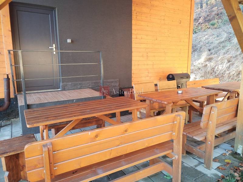 Ház a Stráňachban, Martinban, fa padokkal és grillsütővel a teraszon.