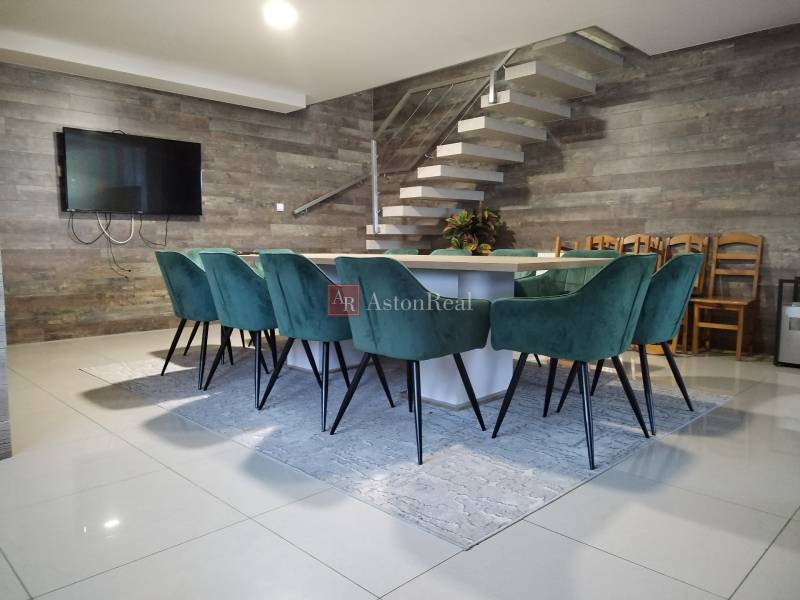 Étkezőasztal türkiz székekkel fahatású padlón.