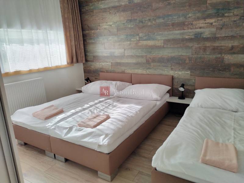 Szoba egy faházban két ággyal, fa falakkal és fa dekorációjú padlóval.