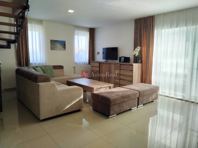 Nappali a faházban kanapéval, televízióval és fa dekorációjú padlóval.