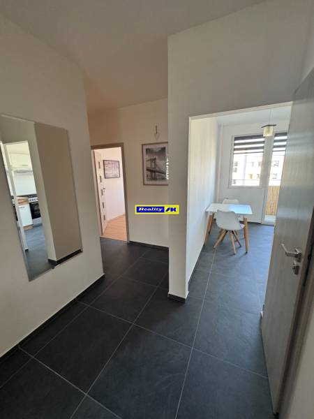 Folyosó sötét csempével és étkezővel egy 3 szobás lakásban.