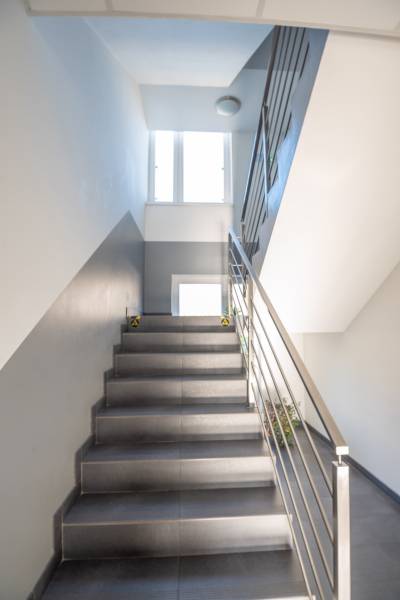 Fémkorláttal ellátott lépcső vezet az irodák ablakához.