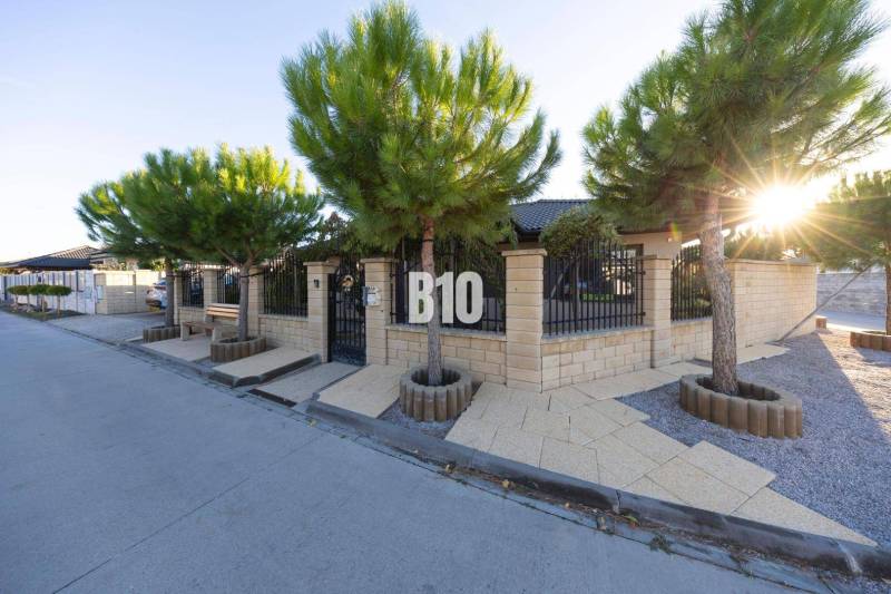 Családi ház Dunaszerdahelyen kőkerítéssel és faültetéssel.