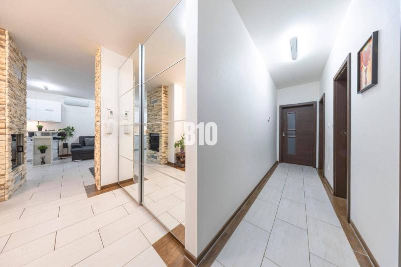 Családi ház folyosója csempével és tükrös fallal.