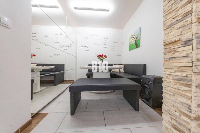 Családi ház belső tere ülőhellyel, tükrös fallal és dekoratív burkolattal.