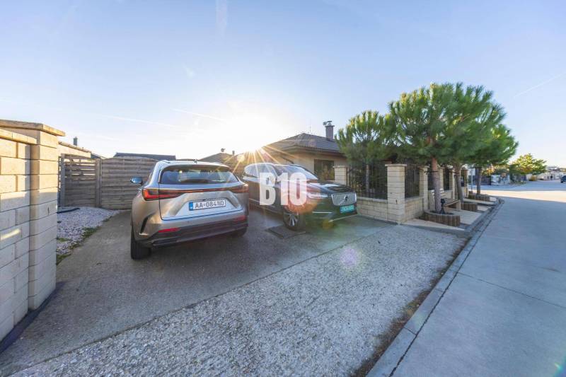 A pozsonypüspöki családi ház udvara parkolóhelyekkel és parkoló autókkal.