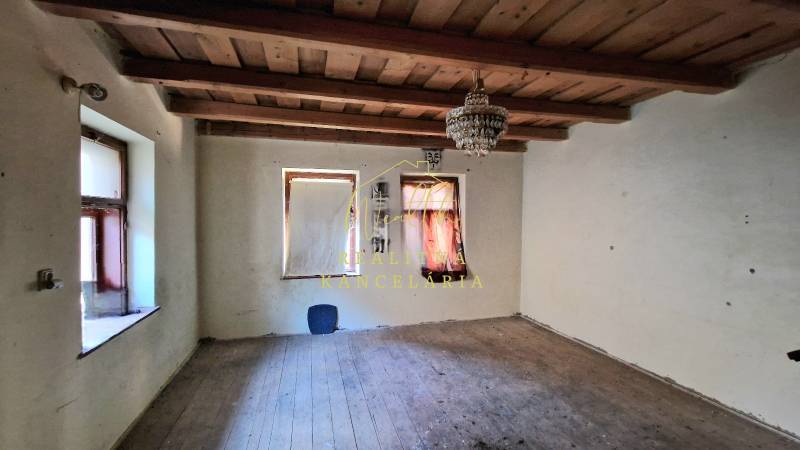 Szoba egy családi házban fa mennyezettel és fa dekorációjú padlóval.