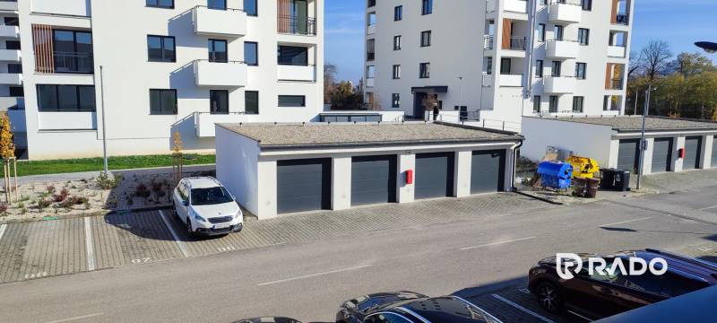 Kilátás a trenčíni Predmerského utcára, lakóházzal és parkolóval.