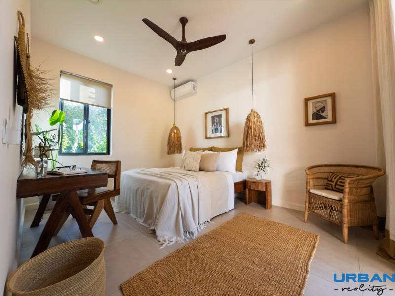 Világos hálószoba függőlámpákkal és fonott bútorokkal egy családi házban.